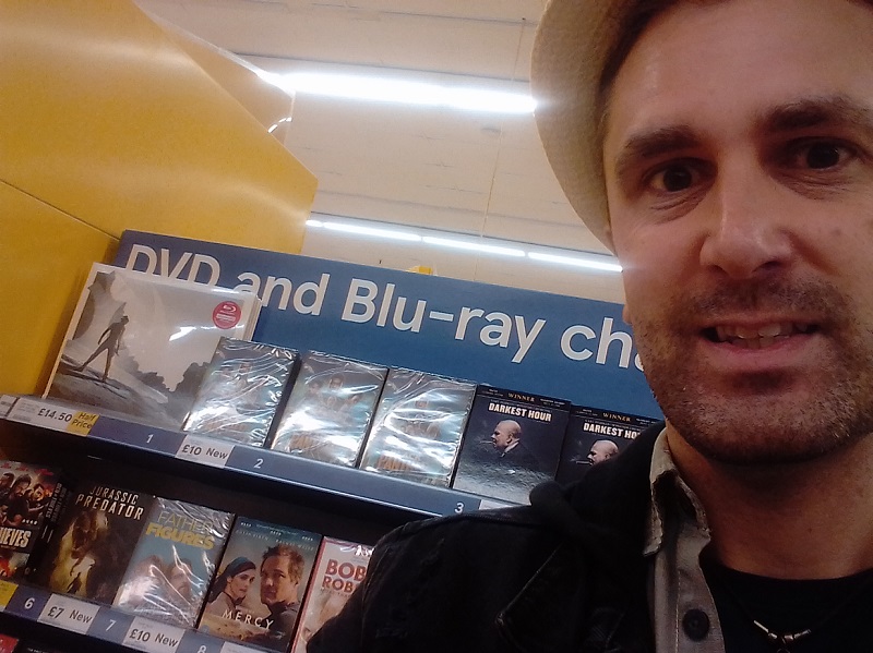 Nathan Head with Jurassic Predator DVDs in Tesco supermarket in Chester